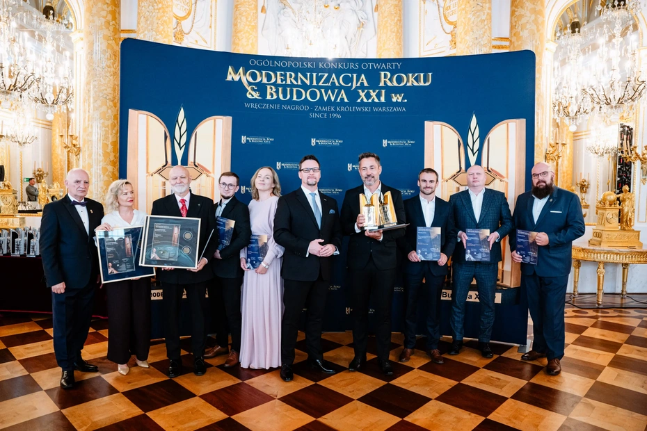 Grupa osób na scenie z dyplomami i statuetkami podczas gali konkursu Modernizacja Roku i Budowa XXI w.
